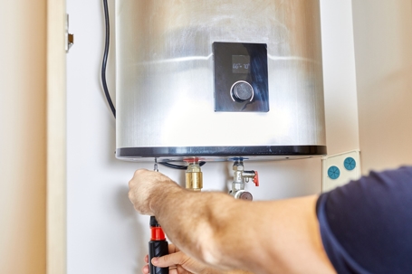tech fixing water heater